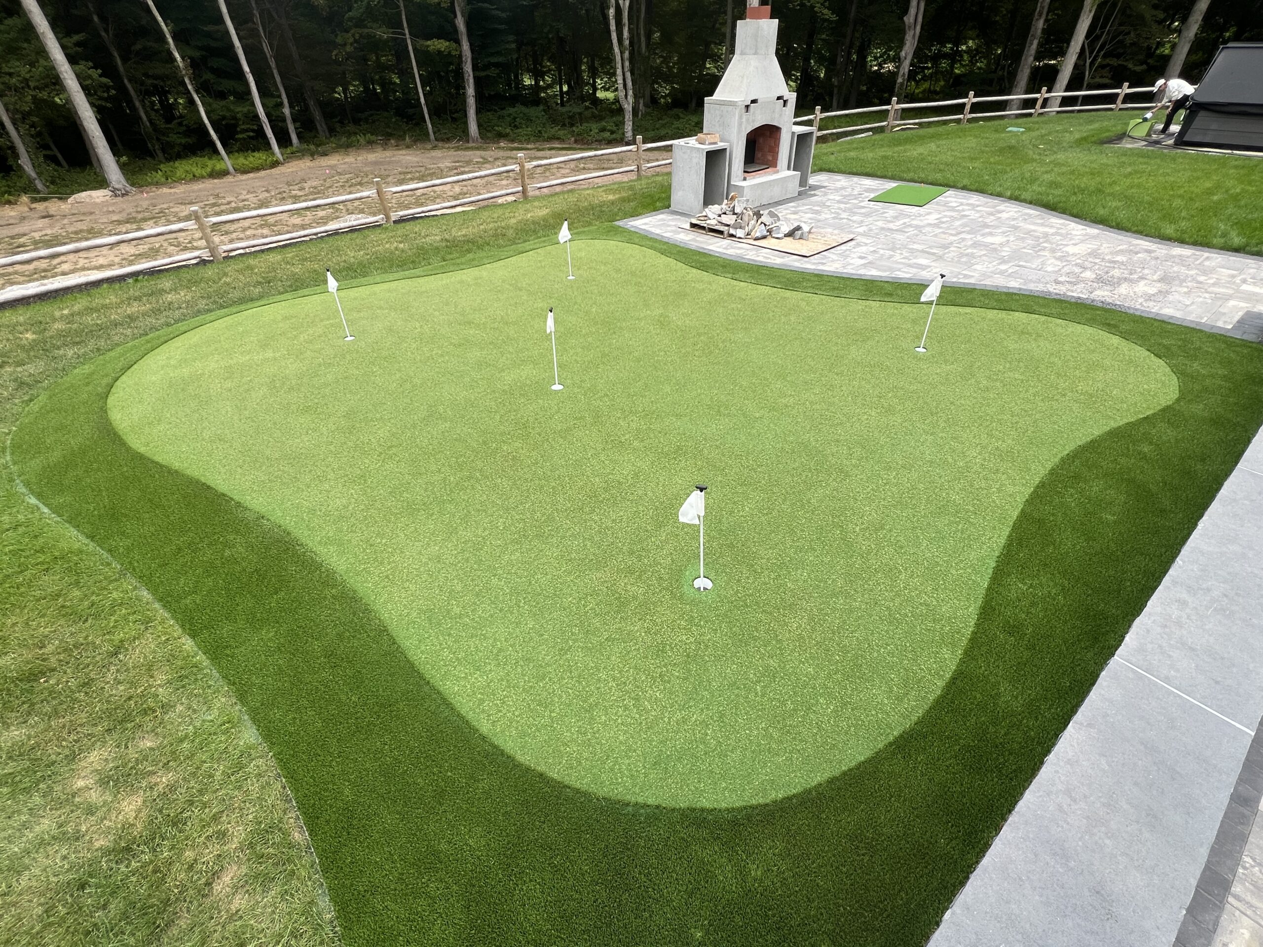Golf ball with putter and corner hole on green artificial turf